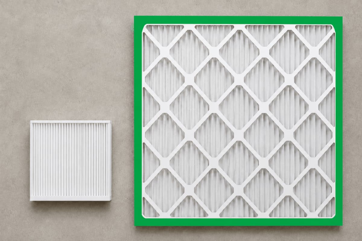 Automotive cabin air filter shown beside a residential HVAC air filter at true relative scale. 